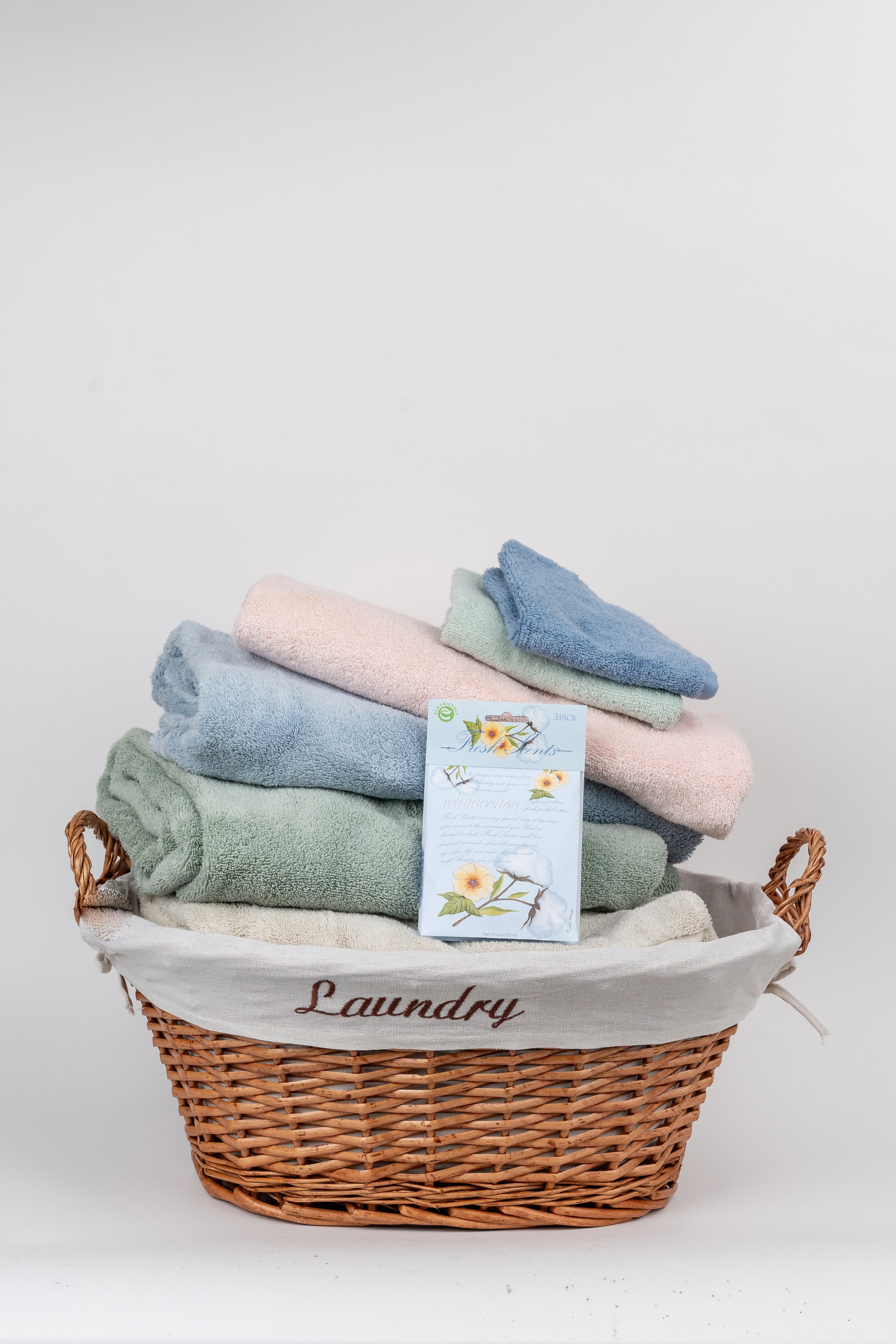 Scented White Cotton Sachet on Basket of Clean Towels