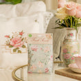 Load image into Gallery viewer, A pack of scented sachets with a floral design, labeled 'Roses', displayed on a glass table with a chinoiserie vase of roses.
