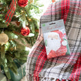 Load image into Gallery viewer, A pack of three scented sachets with a Christmas-themed design, featuring Santa Claus and displayed on a plaid blanket next to a christmas tree.