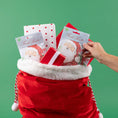 Load image into Gallery viewer, A pack of three scented sachets with a Christmas-themed design, featuring Santa Claus and displayed in a red velvet sack with gifts.