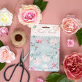 Load image into Gallery viewer, A pack of scented sachets with a floral design, labeled 'Roses', displayed on a pink background with roses and garden scissors