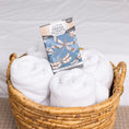 Load image into Gallery viewer, A woven basket with four rolled white towels holds a Fresh Scents "Live in the Moment" Sachet 3pk, featuring a dragonfly design. Enjoy long-lasting freshness as it rests on a fabric surface.
