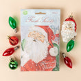 Load image into Gallery viewer, A pack of three scented sachets with a Christmas-themed design, featuring Santa Claus and holiday decorations.