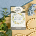 Load image into Gallery viewer, The Fresh Scents Lets Stay Home - Sachet 3pk features a floral wreath design and is displayed on beige with greenery, a beaded garland, blue cloth, and blue flowers—ideal for long-lasting fragrance from scented sachets.