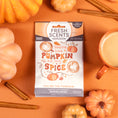 Load image into Gallery viewer, The Fresh Scents "You're the Pumpkin - Sachet 3pk" features a packet reading “You’re the pumpkin to my spice,” shown on an orange surface with mini pumpkins, cinnamon sticks, and a mug—an inviting flameless air freshener with long-lasting fragrance.
