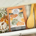 Load image into Gallery viewer, The Fresh Scents Spiced Pumpkin - Sachet 3pk adds long-lasting, flameless fragrance to your space and pairs perfectly with a pumpkin-patterned cloth, orange waffle towel, and wooden utensils for a cozy touch.