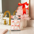 Load image into Gallery viewer, A Fresh Scents Merry Santas - Sachet 3pk sits by a gold faucet and pink Christmas tree with red bow, reflected in the mirror—a festive, flameless fragrance for your bathroom this season.
