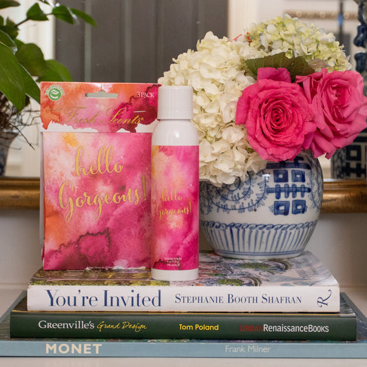 Hello Gorgeous Fragrance in Sachet and Room Spray on Books Next to Bouquet