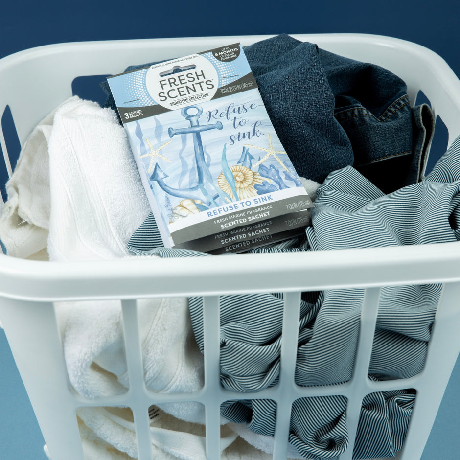 Laundry basket with clothes and a 'Fresh Scents' sachet