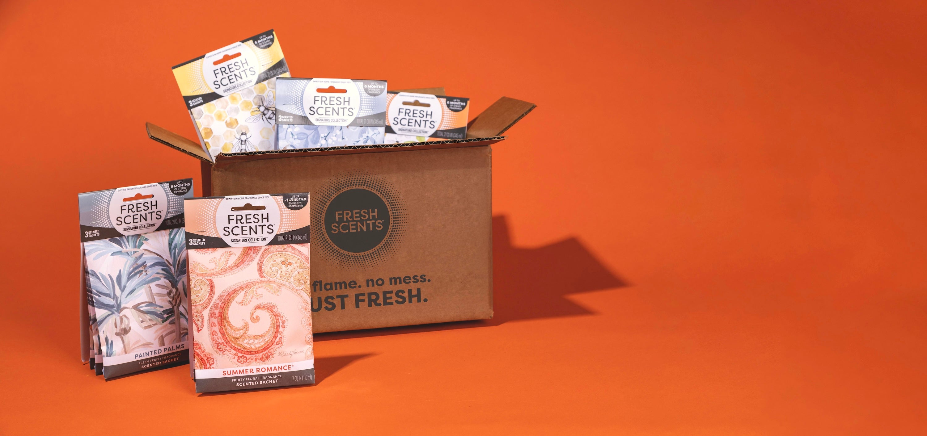 Cardboard box with 'Fresh Scents' products on an orange background