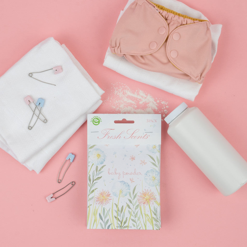 Baby Powder scented sachet flatlay on pink background with diaper