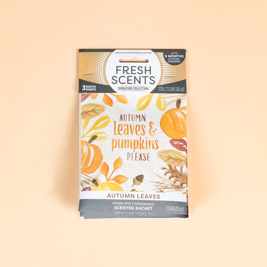 Fresh Scents Autumn Leaves - Sachet 3pk features autumn leaves and pumpkins on a light orange background. Enjoy long-lasting, flameless fragrance for your space with this scented sachet package.