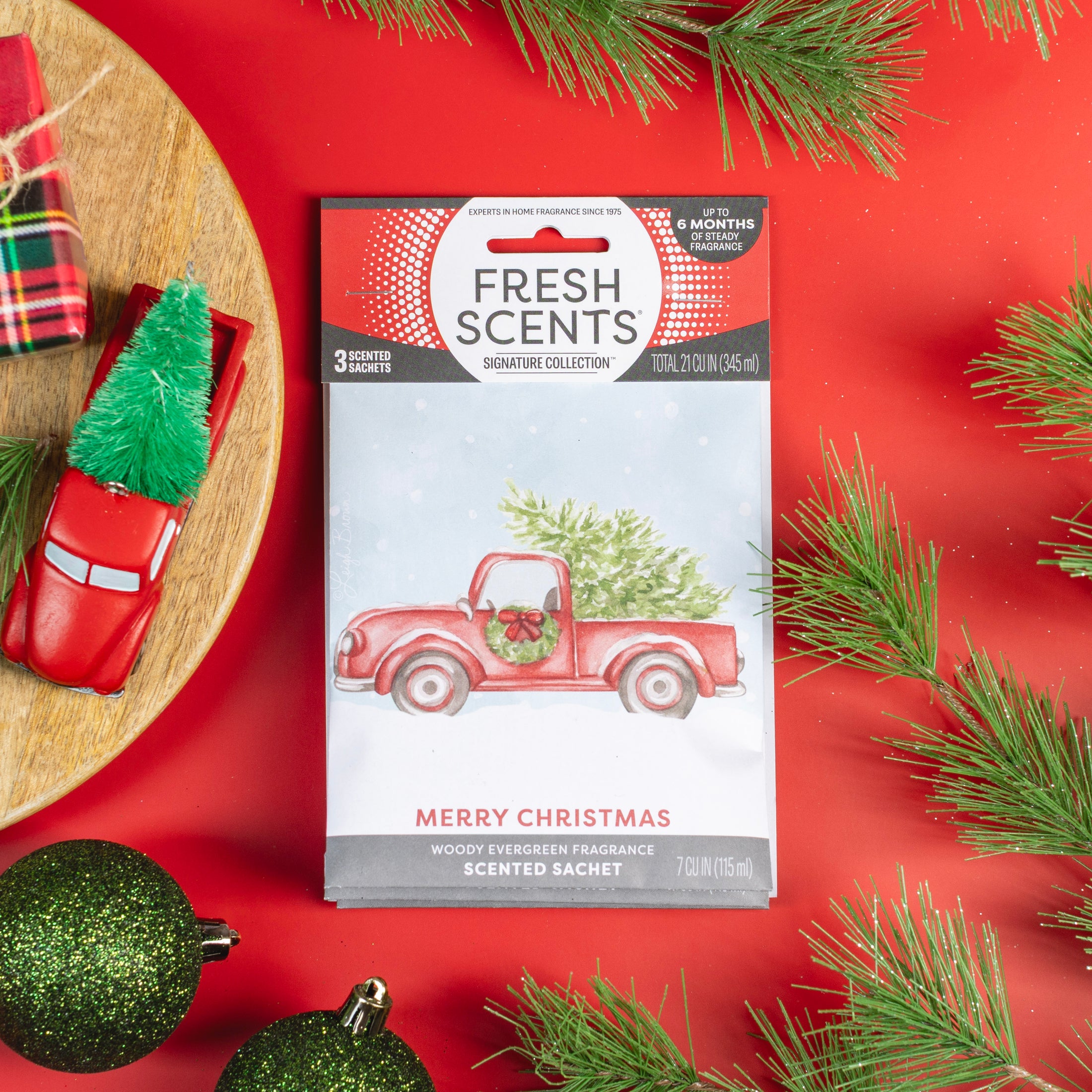 The Fresh Scents Merry Christmas - Sachet 3pk features festive red packets with a red truck and Christmas tree design, offering long-lasting flameless fragrance—perfect for holiday freshness in any space.
