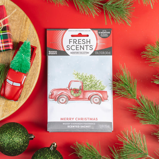 The Fresh Scents Merry Christmas - Sachet 3pk features festive red packets with a red truck and Christmas tree design, offering long-lasting flameless fragrance—perfect for holiday freshness in any space.