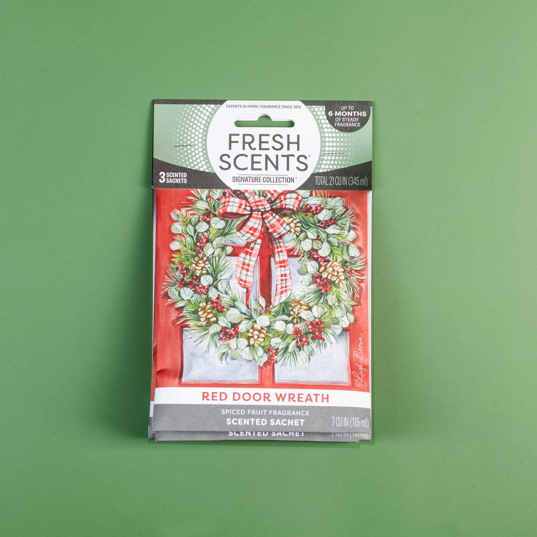 Fresh Scents Red Door Wreath - Sachet 3pk provides flameless, long-lasting spiced fruit fragrance. The package shows a holiday wreath with red plaid bow on a green background for a festive touch.