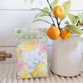 Load image into Gallery viewer, Hello Sunshine Citrus Fragrance Sachet Next to Vase with Orange Stems
