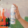Load image into Gallery viewer, Watermark Scented Room Spray in Hand Against Painted Background
