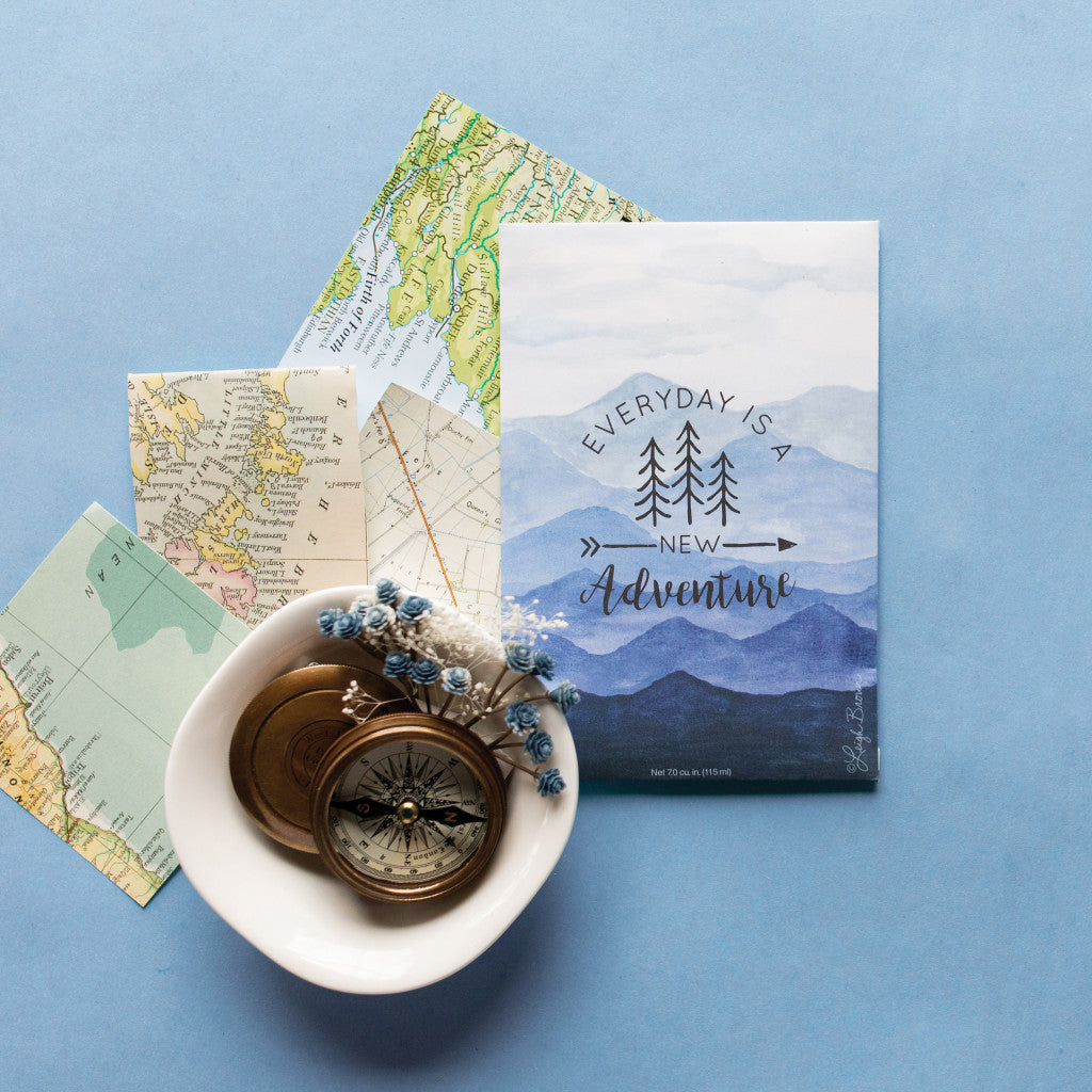 Adventure Mountain Sachet Flatlay on Blue Background with Maps and Compass