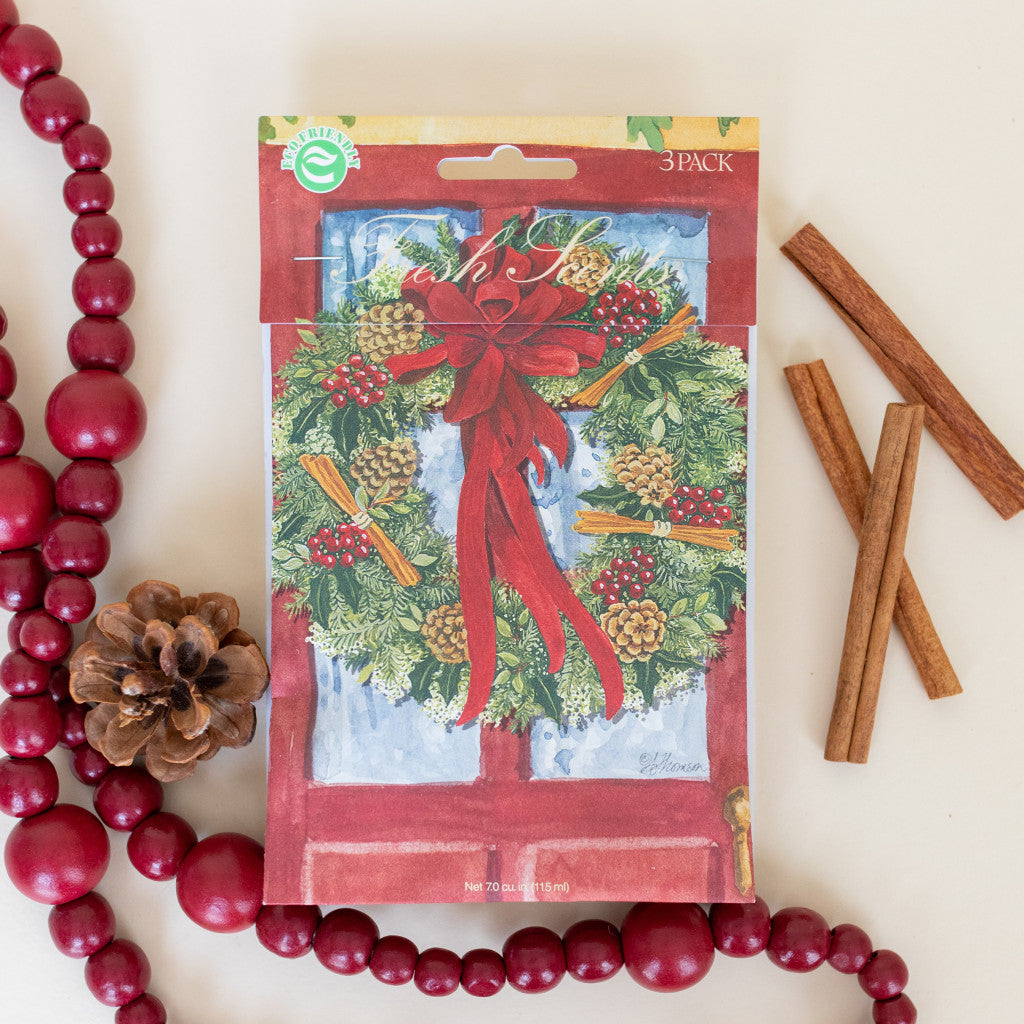 Red Door Wreath Fresh Scents scented sachets flat lay with wooden garland and cinnamon sticks
